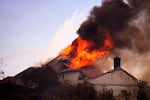 A roof engulfed in flames is seen during the Norte Fire on Friday, Oct. 16, 2026, in San Juan Capistrano, Calif.