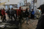 People mourn as they collect the bodies of friends and relatives killed in an airstrike on Jan. 24.