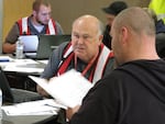 A Red Cross volunteer helps a man who's had to move out of his apartment complex because of a slow-moving landslide.