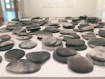 "110 Stones", 2015. pit-fired ceramic. Jensen: "One of the last things I made in a kind of meditative process as I was leaving New York. My address in New York was 110 Bridge Street. They were handmade and then pit-fired here in my yard in Oregon. They have a hand-made passage from Brooklyn here to Portland. They're about a holding and releasing."