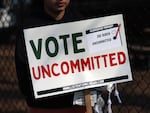 An "uncommitted" voter holds a sign opposing President Biden’s policy toward Israel’s war in Gaza, outside a polling place in Dearborn, Mich., ahead of that state's presidential primary in February.