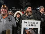 Rory Szwed, left, and Kent Rowan watch the festivities while waiting for Punxsutawney Phil to make his prediction at Gobbler's Knob in Punxsutawney, Pa., early Thursday morning.