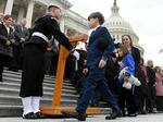 Shannon Terranova, widow of Capitol Police Officer Police Williams Evans, and their children Logan and Abigail, join a bipartisan group of lawmakers on the east front steps of the US Capitol to honor the police officers who lost their lives in the attack on the Capitol, on the second anniversary of the January 6, 2021.
