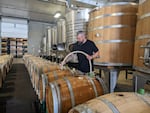 Winemaker Mitch Venohr soaks some wooden wine barrels to prepare them for wine. Barrels are hydrated to tighten the wood and prevent leaking.