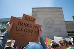 Demonstrators raise signs during a rally outside the National Institutes of Health on May 10, 2025 in Bethesda, Maryland.