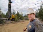 Aiken Well Drilling's Neil Fagen is splattered with wet sand as he works to build a domestic well east of Bend, Ore., July 5, 2022.