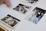 On June 11, 2026, I. Riley Helmstetter, 102, holds out a photo album filled with her memories from 1943. In the two images on the left, Helmstetter and her soon-to-be husband, Hughbert Conner, pose with Helmstetter’s younger sisters by a tree on the family’s farm in northeast Washington. In the image on the right, Helmstetter shakes snow off her foot.