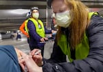 FILE - In this Jan. 10, 2021, file photo, pharmacist Colleen Naughtin, right, administers the Moderna COVID-19 vaccine at a drive-thru vaccination clinic in Portland, Ore.