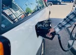 In this undated file photo, a person pumps gas into their car. 