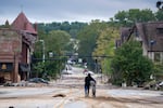 A woman walks along a road in Asheville.