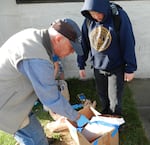 A classroom volunteer explains the importance of a keel in boat construction to Coos Bay middle school student Logan Ford.