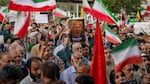 Iranian protesters chant slogans and one holds a poster with a vampire-like illustration of President Trump in Tehran's Revolution Square on Sunday to protest the U.S. attacks on nuclear sites in Iran.