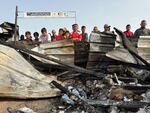 Palestinians look at the damage done by an Israeli airstrike on an encampment for displaced people on Sunday, May 26, near the southern Gaza city of Rafah. Gaza officials say 35 Palestinians were killed in the strike.