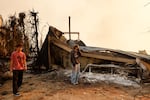 Fallon Prockiw-Kline, center, gets emotional in front of her home which was damaged by the Palisades Fire, in Malibu, California.