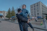 Dmytro Kluchnikov holds his son Artem in his arms at a playground in the center of Sloviansk.