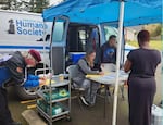 Oregon Coast Humane Society volunteers and employees offer free microchips, vaccines, and pet food and supplies to those in need at a Lane County Stand Down event.