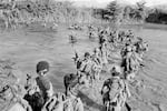 Salvadoran members of the Atlacatl battalion cross a river during a military operation in San Miguel department, El Salvador, circa late August to early September 1983. (Photo by Robert Nickelsberg/Getty Images)