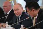 Russian President Vladimir Putin, center, looks at President of Xinhua News Agency Fu Hua, right, while speaking to representatives of international news agencies as General Director of the Russian news agency TASS, Andrey Kondrashov, left, sits near on the sidelines of the St. Petersburg International Economic Forum at the Constantine Palace in St. Petersburg, Russia, on Thursday, June 4, 2026.