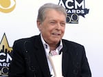 FILE - Mickey Gilley poses with the Triple Crown Award on the red carpet at the 50th annual Academy of Country Music Awards at AT&T Stadium in Arlington, Texas, April 19, 2015. Gilley, whose namesake Texas honky-tonk inspired the 1980 film “Urban Cowboy,” and a nationwide wave of Western-themed nightspots, died Saturday, May 7, 2022, at age 86.