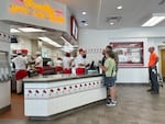 Customers place order at the counter of an In-N-Out burger restaurant Tuesday, Aug. 8, 2023, in Thornton, Colo.