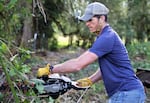 Hunt By Reservation coordinator Brandon Dyches, helps clear brush at an Albany farm to show appreciation for hunters being allowed to hunt on the property in August.