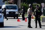 A federal agent, center, walks to his vehicle outside an ICE processing facility in the Chicago suburb of Broadview, Ill., on Oct. 21, 2025.
