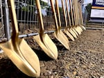 A row of gold-painted shovels await their time during a groundbreaking ceremony at 240 NW 4th Street in Corvallis, Ore., on Wednesday, June 14, 2023. The site will be home to a new crisis center slated to open in summer 2024.