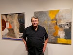 John Feodorov, Diné, stands near two of his mixed media paintings during the “Citizen Fellow: Art as Archive and Memory” exhibition opening on Sept. 19, 2024 at the Center for Native Arts and Cultures. NACF elected Feodorov as one of the artists for its national artist fellowship in 2011.