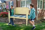 Jenna Fournel and Leal Abbatiello, 14, carry a daybed frame to display their produce at their home in Alexandria, Va. on April 30, 2022.