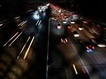 In a long exposure image, cars and trucks drive on the 405 Freeway during Los Angeles rush hour traffic in March 2022.