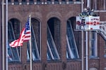 Firefighters ride in an aerial ladder as they inspect buildings damaged in a Christmas Day explosion Monday, Dec. 28, 2020, in Nashville, Tenn. Federal officials now turn to exploring the monumental task of piecing together the motive behind the bombing that severely damaged dozens of downtown Nashville buildings and injured three.