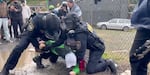 A still image captured by OPB from a video submitted in court via defense attorneys for Oriana Korol. The image shows Korol being held down and arrested by federal law enforcement officers outside the Portland ICE facility last October.