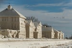 Geese fly over frozen homes in the waterfront community of Crystal Beach in Fort Erie, Ontario, Canada.