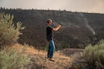 Clay Jacobsen of Seattle, Wash., stops to take a photo of the acres of burned land from the Bench Fire off Highway 26 between Warm Springs and Madras, Ore., on July 27, 2026. “It looks apocalyptic,” said Jacobsen, who was traveling through the area while on a business trip.