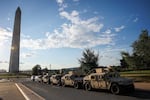 Military vehicles with the Washington, D.C. National Guard park near D.C.'s Washington Monument.