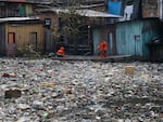 Workers remove garbage floating on the Negro River in Manaus, Brazil.