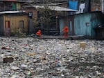 Workers remove garbage floating on the Negro River in Manaus, Brazil.