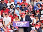 Trump starts ducking downward after gunfire rings out during the campaign rally in Butler.