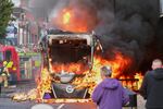 People watch as firemen arrive to put out vehicle that was set alight during a protest in East Belfast following a stabbing incident in Belfast, Tuesday, June 9, 2026.