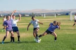 Manchester United players Yesenia Gonzaga, center, and Elida Leyva, in white, fight for possession against Purple Reign at the semifinal game June 17. Manchester United advanced to the final, which will be held June 24 in Pasco.
