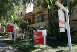 For-sale signs are staked into the ground in front of condominiums for sale in July in Los Angeles.