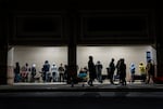 people stand in line at night in front of a building