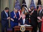 President Biden hands a pen to Sen. Joe Manchin during the signing ceremony for the Inflation Reduction Act. Manchin was a key hold-out during negotiations, insisting on a smaller spending bill.