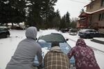 Neighbors help push an abandoned car out of the right of way on Harney Rd. in the Lents neighborhood of Portland, Dec. 15, 2016.
