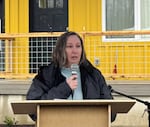 As a steady rain falls, Lane County Commissioner Heather Buch speaks to a large crowd at the Grand Opening of Lazy Days housing community in Blue River.