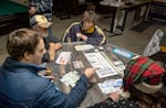 Sean Wittmeyer, first from left, explains how to play his PDX board game — inspired by the Portland Airport’s recent renovations — to a group during a December meeting of the Gamecrafters' Guild.