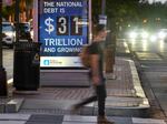 A poster at a bus shelter shows the national debt in Washington, D.C., on May 21, 2023. The U.S. is facing the prospect of default as political leaders race to clinch a deal to raise or suspend the debt ceiling. Currently the country can borrow up to $31.4 trillion.