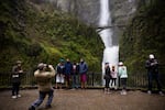Tourists take pictures next to Multnomah Falls, April 13, 2018.