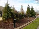 "Host Analog", Buster Simpson, 1991, Oregon Convention Center, stainless steel irrigation, basalt, old growth (windfall) logs, city water, porcelain enamel signage. 17' x 90' x 30'.