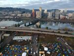 In this aerial photo taken with a drone, homeless camps are seen in a vacant parking lot on the central eastside in Portland, Ore., Tuesday, Dec. 8, 2020.